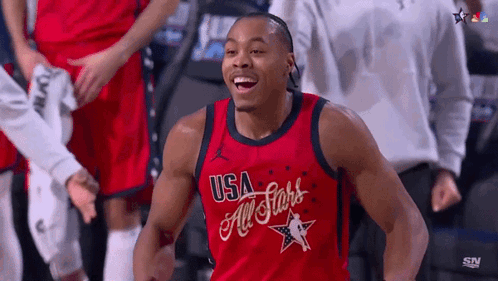 a man wearing a red usa all stars jersey is smiling