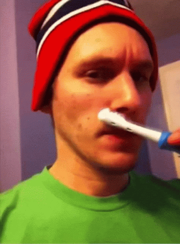 A Man Wearing A Red White And Blue Hat Brushing His Teeth GIF