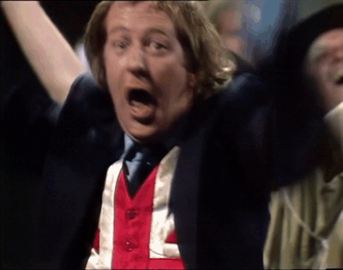 A Man Wearing A Red White And Blue Vest That Says L On It GIF