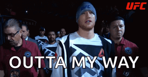 A Man Wearing A Reebok Shirt Walks Into A Ufc Ring GIF