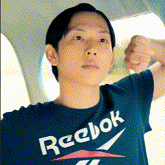 A Man Wearing A Reebok T-Shirt Is Flexing His Muscles GIF