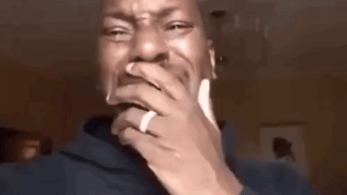 A Man Wearing A Ring On His Finger Is Covering His Mouth With His Hand . GIF