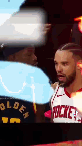 A Man Wearing A Rockets Jersey Stands Next To Another Man GIF