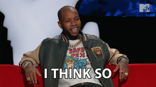A Man Wearing A Safe Sex T-Shirt Sits On A Red Couch GIF