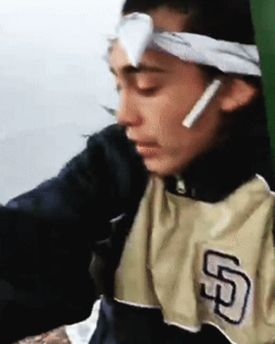 A Man Wearing A San Diego Padres Shirt Has A Bandage On His Forehead . GIF