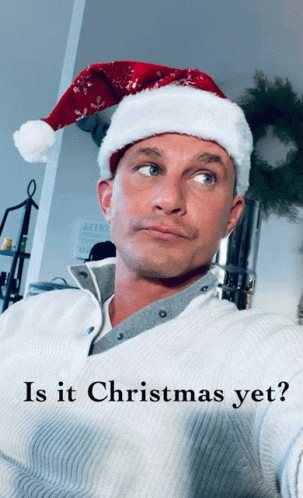 A Man Wearing A Santa Hat Is Asking If Christmas Is Yet GIF