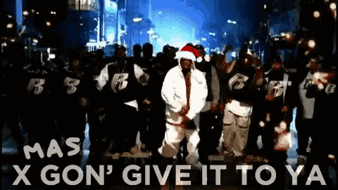 A Man Wearing A Santa Hat Is Dancing In Front Of A Crowd With The Words X Gon ' Give It To Ya GIF