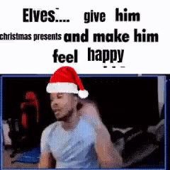 A Man Wearing A Santa Hat Is Sitting In Front Of A Screen . GIF