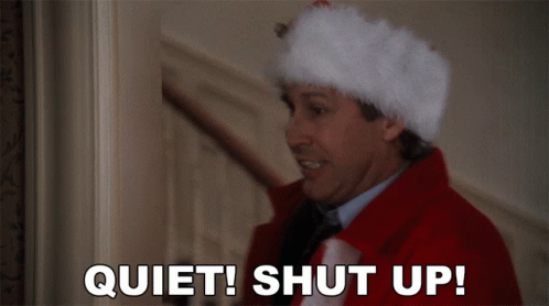 A Man Wearing A Santa Hat Says " Quiet Shut Up " GIF
