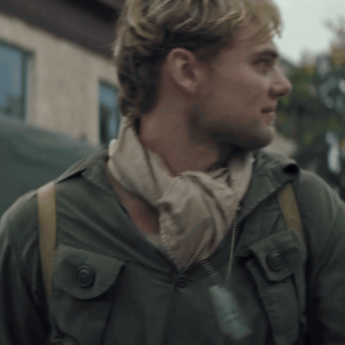 A Man Wearing A Scarf Around His Neck And A Jacket GIF