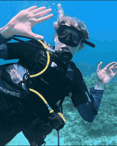 A Man Wearing A Scubapro Scuba Diving Suit Is Swimming In The Ocean GIF