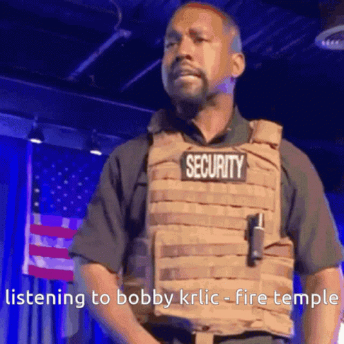 A Man Wearing A Security Vest Is Standing In Front Of An American Flag . GIF