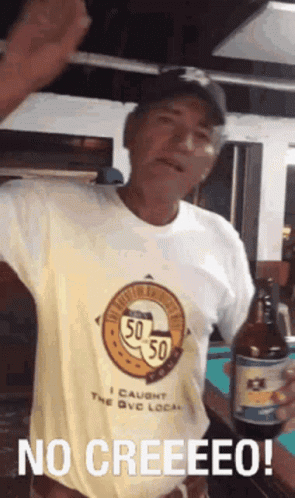 A Man Wearing A Shirt That Says 50 50 Is Holding A Beer Bottle GIF