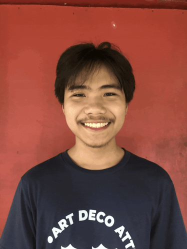 A Man Wearing A Shirt That Says " Art Deco Att " Smiles For The Camera GIF