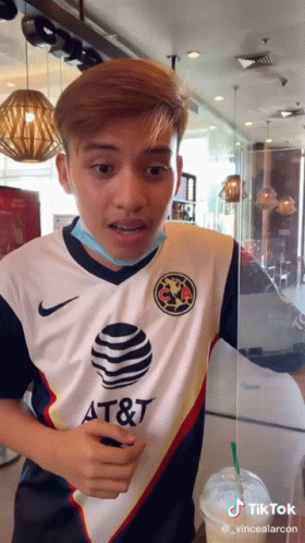 A Man Wearing A Shirt That Says At & T Is Standing In A Restaurant GIF