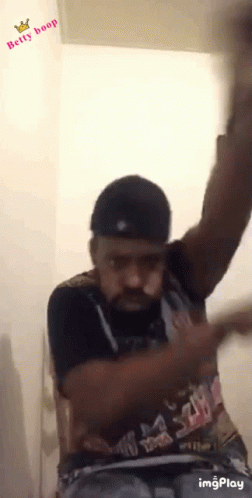 A Man Wearing A Shirt That Says Betty Boop Is Dancing GIF