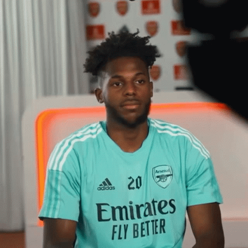 a man wearing a shirt that says emirates fly better on it