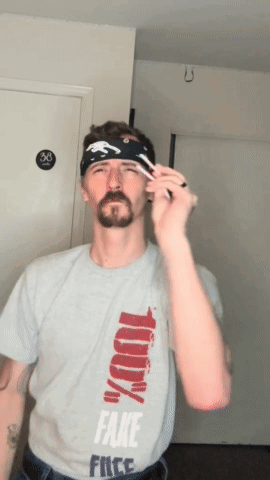 A Man Wearing A Shirt That Says Fake Free GIF