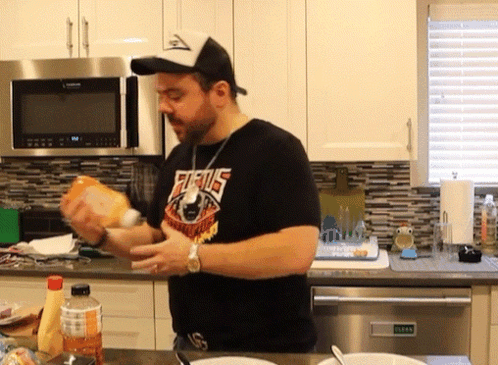 A Man Wearing A Shirt That Says Furius Is Preparing Food In A Kitchen GIF