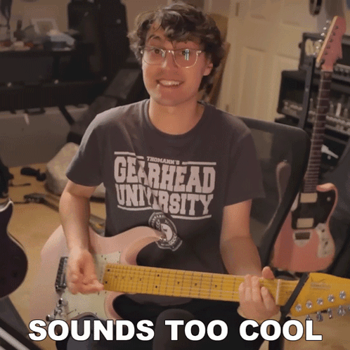 Man Holding Guitar With Gearhead University Shirt GIF