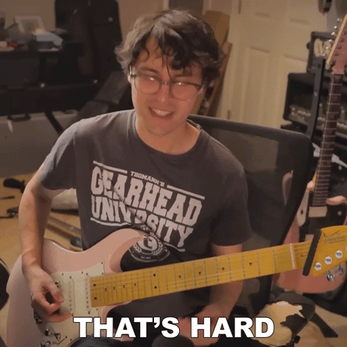 A Man Wearing A Shirt That Says Gearhead University Playing A Guitar GIF