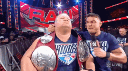 A Man Wearing A Shirt That Says ' Hodogs ' On It Is Being Held By Another Man GIF