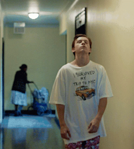 A Man Wearing A Shirt That Says " I Survived My Trip To Nyc " GIF