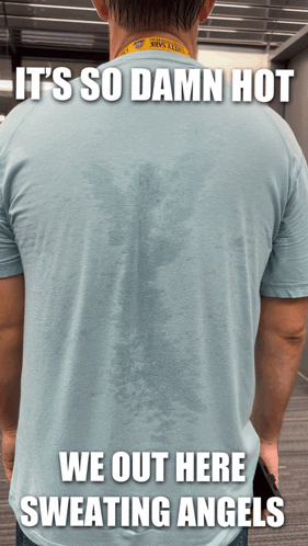 A Man Wearing A Shirt That Says ' It 'S So Damn Hot We Out Here Sweating Angels ' On The Back GIF