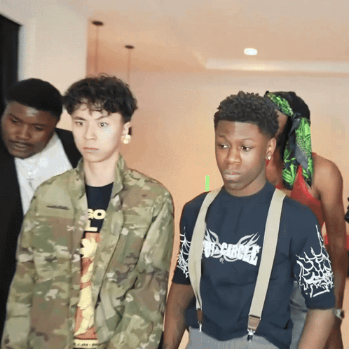 A Man Wearing A Shirt That Says Misfits Is Standing Next To A Man In A Camouflage Jacket GIF
