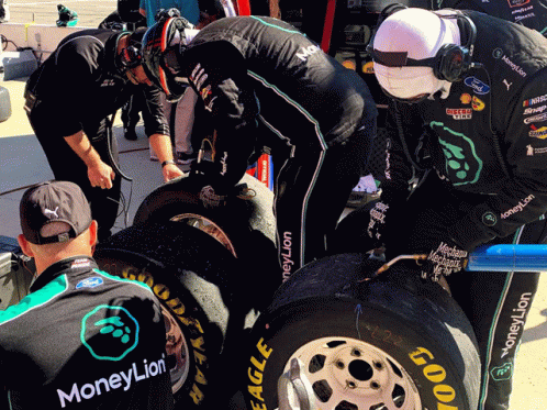 A Man Wearing A Shirt That Says Moneylion Looks At A Tire GIF