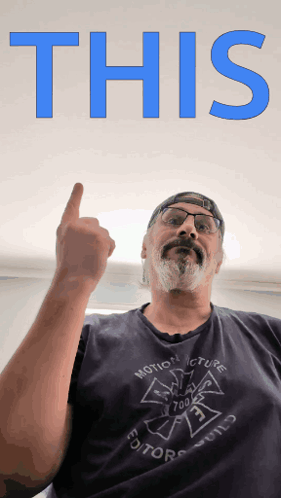 A Man Wearing A Shirt That Says Motion Picture Editor Holds His Finger Up GIF
