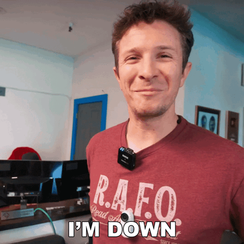 A Man Wearing A Shirt That Says R.a.f.o. Is Smiling GIF