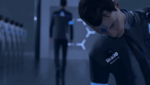 A Man Wearing A Shirt That Says Rk800 Is Looking Down GIF