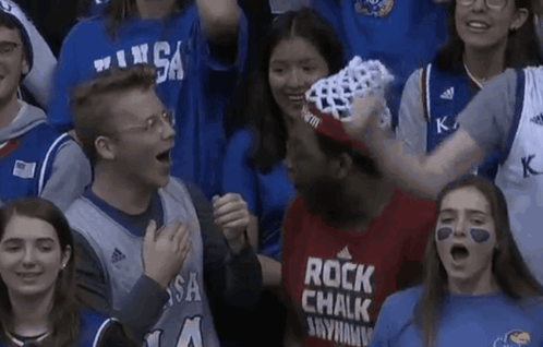 A Man Wearing A Shirt That Says Rock Chalk Anywhere GIF