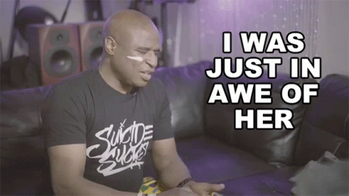 A Man Wearing A Shirt That Says " Suicide Sucks " Sits On A Couch GIF