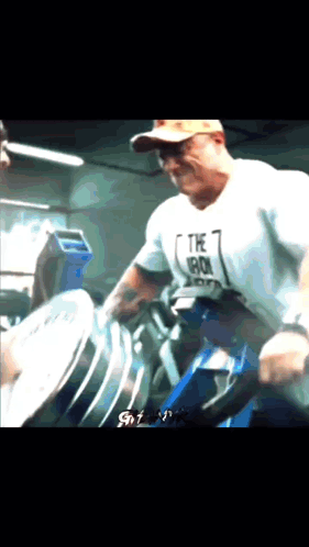 a man wearing a shirt that says the iron is lifting a barbell