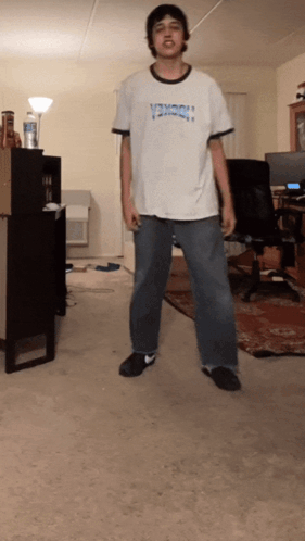A Man Wearing A Shirt That Says Thrasher Is Standing In A Room GIF
