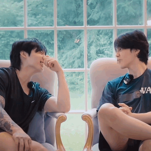 A Man Wearing A Shirt That Says Wa Is Sitting Next To Another Man GIF