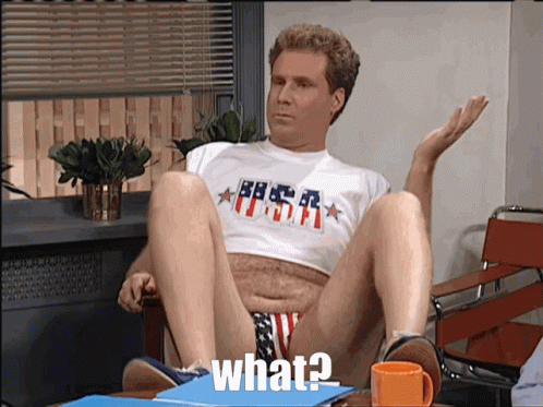 A Man Wearing A Shirt That Says ' What ' On It Sits In A Chair GIF