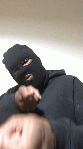 A Man Wearing A Ski Mask Is Pointing His Finger GIF