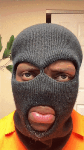 A Man Wearing A Ski Mask With His Tongue Out GIF