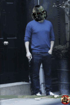 A Man Wearing A Skull Helmet Is Standing In Front Of A Door GIF