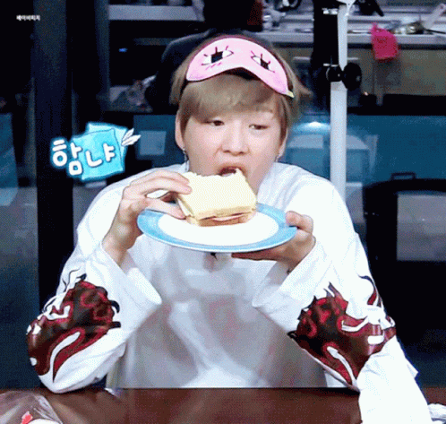 A Man Wearing A Sleep Mask Is Eating A Piece Of Sandwich GIF
