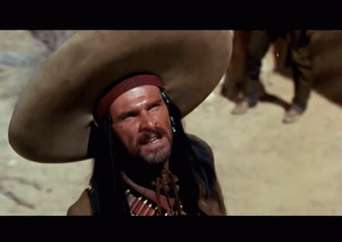 A Man Wearing A Sombrero And A Native American Costume GIF