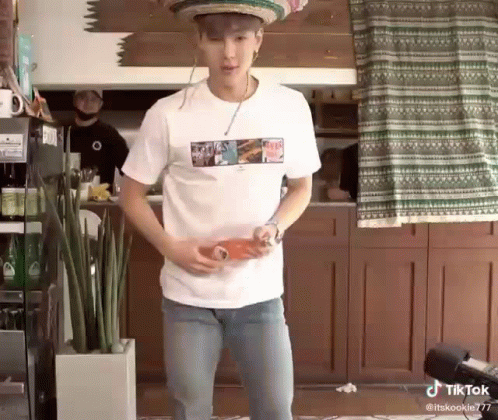 A Man Wearing A Sombrero And A White Shirt Is Holding A Bottle Of Soda . GIF