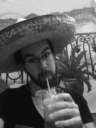 A Man Wearing A Sombrero And Glasses Is Drinking A Drink Through A Straw GIF