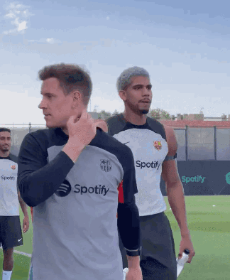 A Man Wearing A Spotify Shirt Stands On A Field GIF
