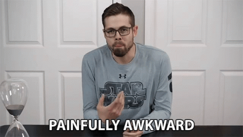 A Man Wearing A Star Wars Shirt Says Painfully Awkward In Front Of An Hourglass GIF