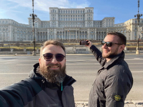 A Man Wearing A Stone Island Jacket Takes A Selfie With Another Man GIF