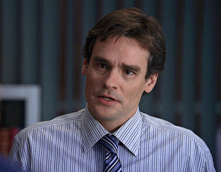 A Man Wearing A Striped Shirt And Tie Looks To The Side GIF